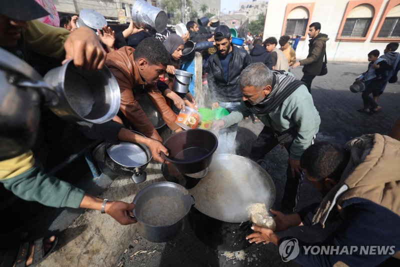 하루 165명 사망…가자지구 피란처 폭격에 아비규환 Palestinians collect food at a donation point in a refugee camp in Rafah in the southern Gaza Strip on December 23, 2023, amid continuing battles between Israel and the militant group Hamas. (Photo by Mahmud HAMS / AFP)