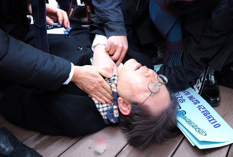 2일 오전 부산 강서구 가덕도신공항 부지 현장에서 피습당한 더불어민주당 이재명 대표가 지혈을 받으며 구급 차량을 기다리고 있다. 연합뉴스