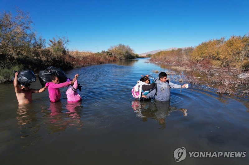 미국 국경에서 강을 건너는 이주민들 epa11049655 Migrants cross the Rio Bravo on their way to the United States fence in Ciudad Juarez, Mexico, 29 December 2023 (issued 30 December 2023). Migrants flood the streets in Ciudad Juarez, hoping to cross to the United States, despite the pressure by authorities from both 