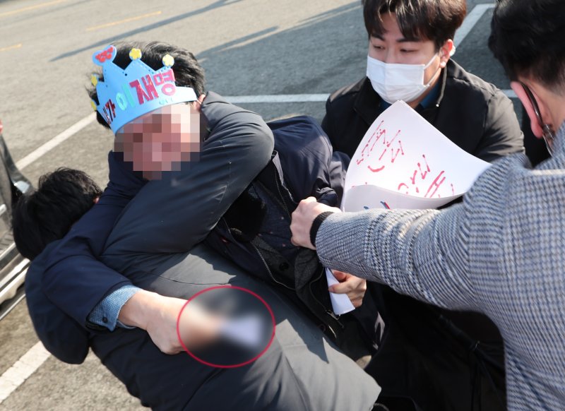 [부산=뉴시스] 하경민 기자 = 2일 오전 부산 강서구 대항전망대에서 이재명 더불어민주당 대표를 흉기로 피습한 옹의자가 흉기를 든 채 경찰에 제압되고 있다. 2024.01.02. yulnetphoto@newsis.com /사진=뉴시스