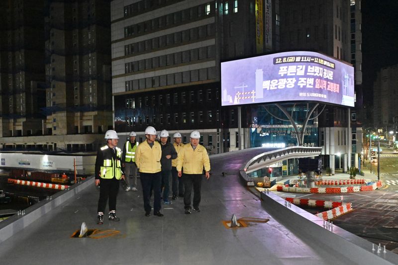 광주광역시 남구가 백운광장 일원에 건립 중인 '푸른길 브릿지'를 설 명절 이전에 임시 개통할 계획이다. 사진은 김병내 남구청장(사진 앞줄 오른쪽에서 첫 번째)이 관계자들과 함께 공사 현장을 점검하고 있는 모습. 남구 제공