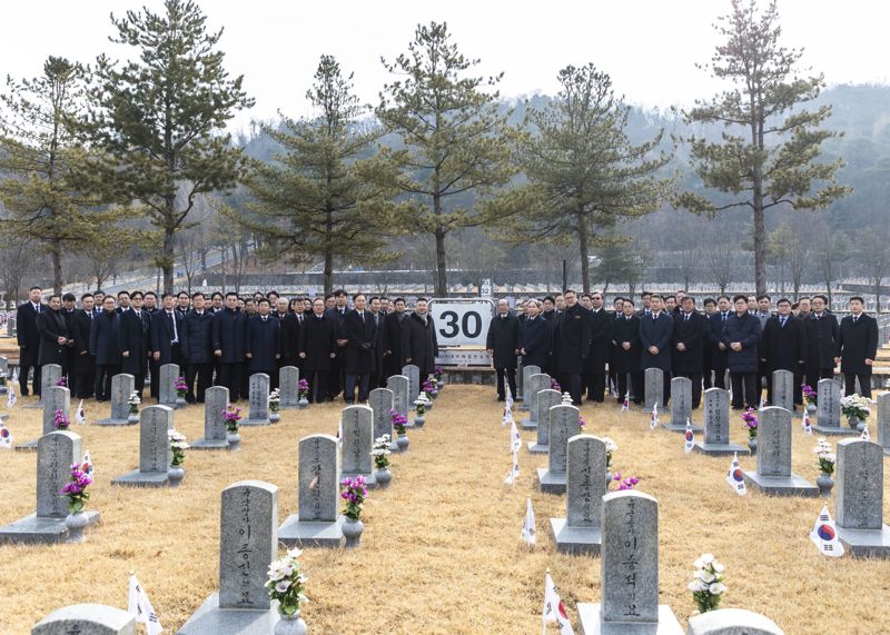 LIG넥스원 등 LIG그룹 계열사 주요 임원진이 서울현충원의 LIG넥스원 자매결연 묘역을 참배하며 기념촬영을 하고 있다. LIG넥스원 제공