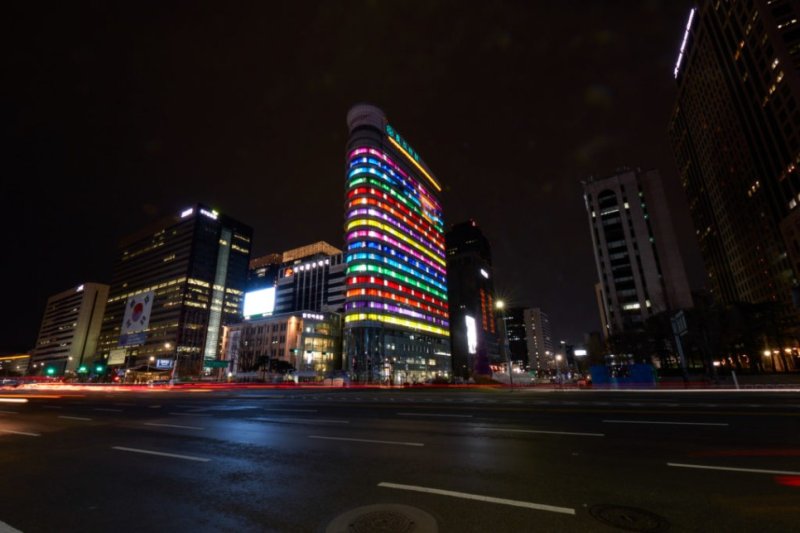 파리의 노상에서 줄무늬 형태의 샌드위치 패널을 몸에 걸친 사람들이 거리를 걷는 퍼포먼스(위쪽). 서울 광화문 동아일보 사옥에 설치된 다니엘 뷔랑의 '한국의 색, 인 시튜'