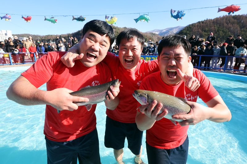 7일 오후 강원 평창군 진부면 오대천 일원에서 열린 평창송어축제를 찾은 관광객들이 맨손으로 송어를 잡아 보이고 있다. 올해 축제는 송어얼음낚시와 송어맨손잡기, 실내낚시 등의 다양한 송어잡기 체험과 눈과 얼음 위에서 즐기는 겨울레포츠 등으로 구성됐으며 28일까지 열린다. (평창군 제공) 2024.1.7/뉴스1