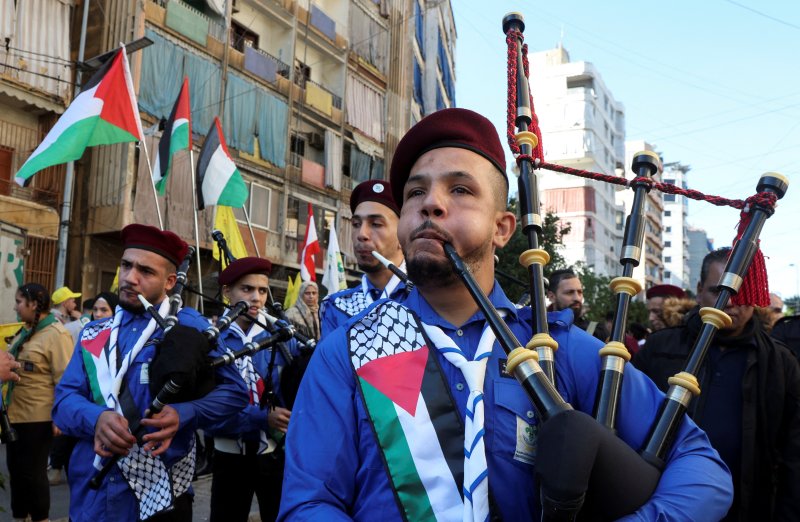 7일(현지시간) 레바논 베이루트에서 순교자의 날을 맞아 악기를 든 팔레스타인 관계자들이 팔레스타인 국기를 두른 채 행진하고 있다.로이터연합뉴스