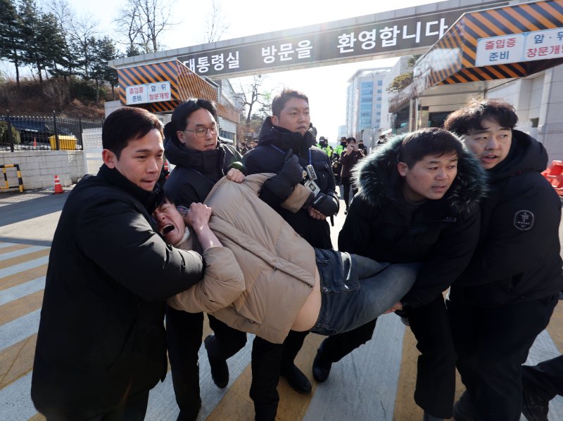 [서울=뉴시스] 홍효식 기자 = 6일 오후 서울 용산구 대통령집무실 입구에서 한국대학생진보연합 대학생들이 ‘윤석열 대통령의 김건희 특검 거부 규탄’ 기습시위 도중 경찰에 연행되고 있다. 2024.01.06. yesphoto@newsis.com