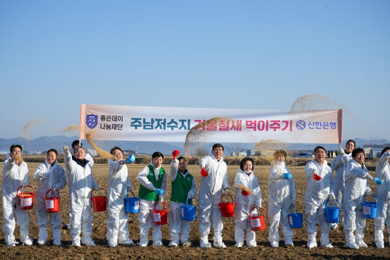 지난 13일 오전 경남 창원시 주남저수지에서 열린 겨울 철새 먹이주기 행사에서 참석자들이 볍씨를 주변 논에 뿌리고 있다. 무학 제공