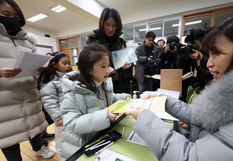 [서울=뉴시스] 홍효식 기자 = 2024학년도 초등학교 신입생 예비소집일인 4일 서울 서초구 원명초등학교에서 입학을 앞둔 어린이가 입학 안내자료를 받고 있다. 2024.01.04. yesphoto@newsis.com /사진=뉴시스