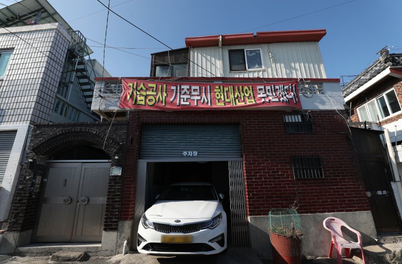 11일 부산 남구 동제당로 인근에 대연3구역 주택재개발정비사업이 진행 중인 가운데 아파트 공사현장 앞 한 주택에 현수막이 내걸려 있다. 2024.1.11/뉴스1 ⓒ News1 윤일지 기자