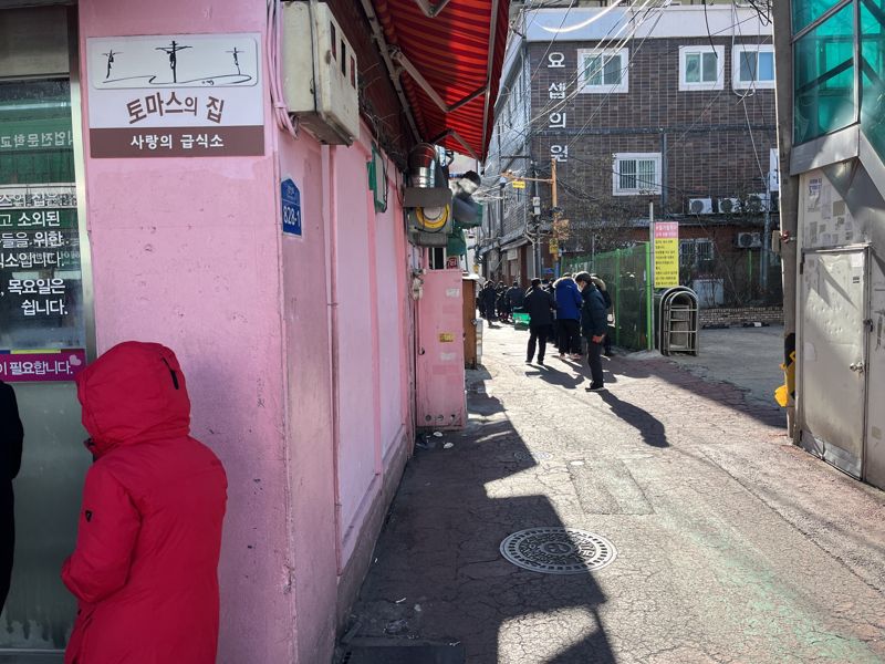 25일 오전 11시께 서울 영등포구 영등포동 토마스의 집 옆 골목에 점심 배식을 위한 줄이 늘어섰다. /사진= 주원규 기자
