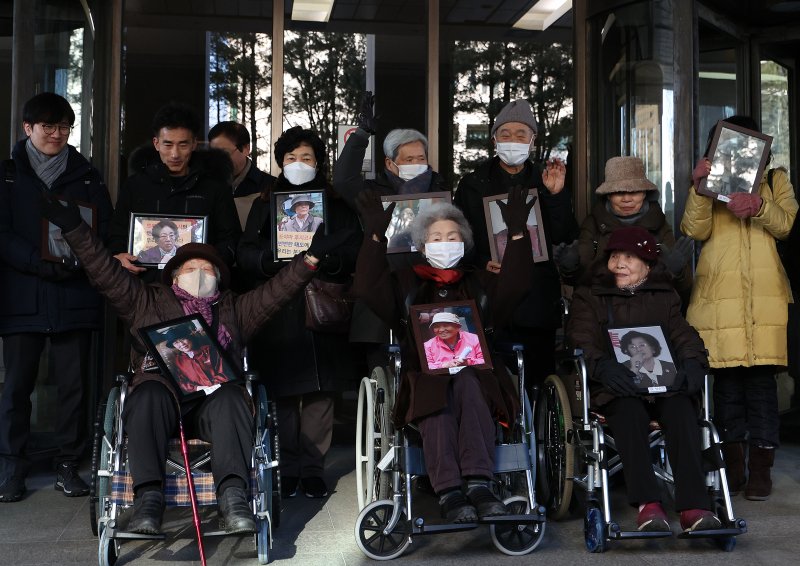 25일 오전 서울 서초구 대법원에서 열린 일제 강제동원 후지코시 상대 손배소송 상고심 선고에서 원고 일부승소 판결 원심을 확정받은 피해자 김정주, 김계순, 이자순 할머니(앞줄 왼쪽부터)와 유족들이 만세를 부르고 있다. 연합뉴스