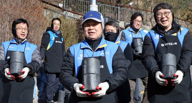 진옥동 신한금융그룹 회장(앞줄 가운데)이 지난 25일 서울시 서대문구 홍제동 개미마을에서 임직원들과 함께 '사랑의 연탄 나눔' 봉사활동을 하고 있다. 진옥동 회장은 이 자리에서 김응철 굿네이버스 사무총장에게 에너지 취약계층 지원 기금 2억원을 전달했다. 신한금융그룹 제공