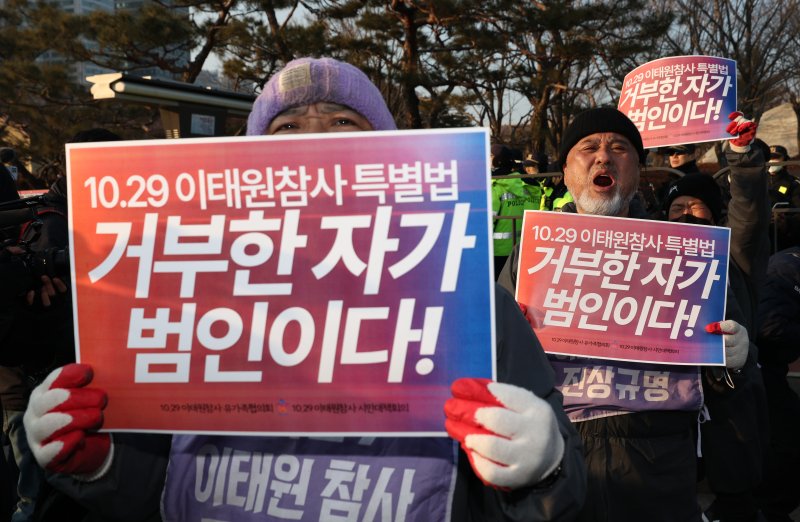 이태원 참사 유가족과 종교인들이 29일 오전 서울 용산구 대통령실 인근에서 이태원 참사 특별법 공포를 촉구하는 손팻말을 들고 구호를 외치고 있다.<div id='ad_body3' class='mbad_bottom' ></div> 사진=연합뉴스