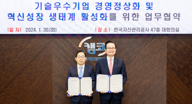 30일 부산국제금융센터 본사에서 열린 '기술 우수 기업 경영정상화 및 혁신성장 생태계 활성화를 위한 업무협약식'에 참석한 권남주 캠코 사장(오른쪽)이 박훈기 부산연합기술지주 대표이사와 협약서를 들고 기념촬영을 하고 있다. 캠코 제공