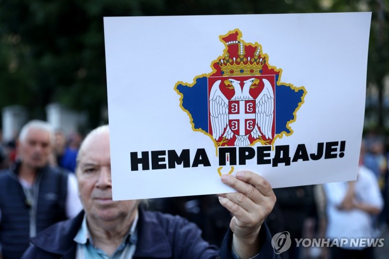 "굴복은 없다"…코소보 북부 세르비아계 주민을 지지하는 시위 epa10715865 A man holds a banner depicting a map of Kosovo in the colors of the Serbian flag and reading in Serbian 'No surrender' during a rally of support for Serbian people in Kosovo, in Belgrade, Serbia, 28 June 2023. Right wing nationalists have protested deman