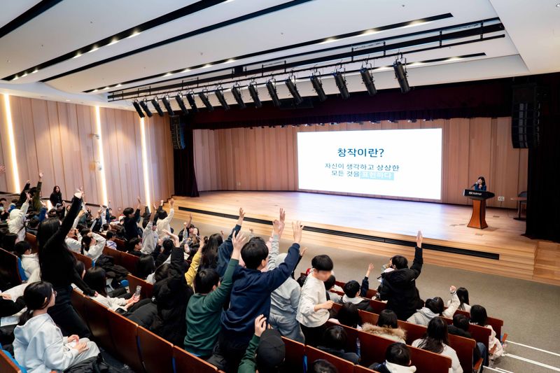 한국콜마 진로·직업 체험의 날 행사에 참석한 언남초등학교 6학년 학생들이 질문을 하기 위해 손을 들고 있다