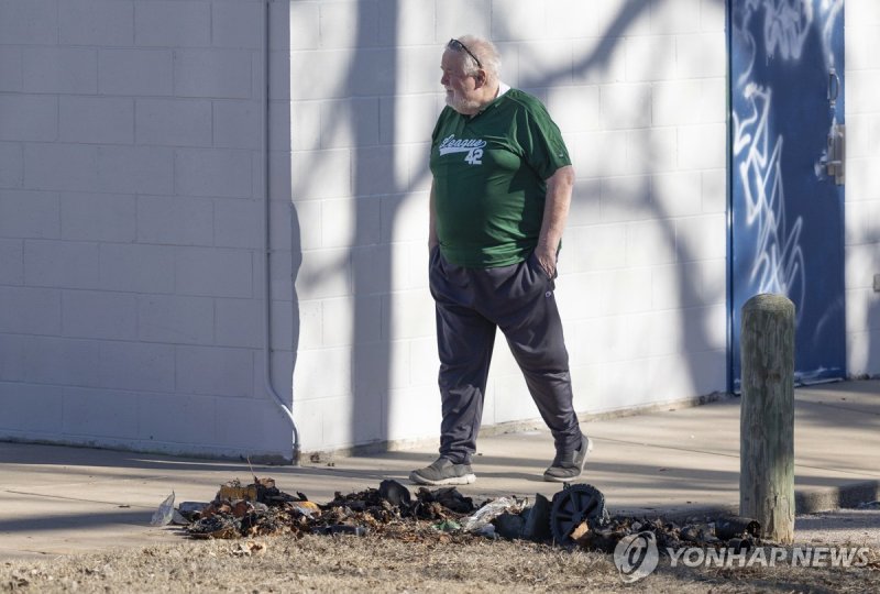 방화로 심하게 훼손된 로빈슨 동상 잔해 Bob Lutz, the executive director of League 42, a youth baseball league in Wichita, Kan., walks past the charred remains of a trash dumpster where pieces of a stolen Jackie Robinson statue were found by Wichita police on Tuesday, Jan. 30, 2024. The life-sized statue of baseball 