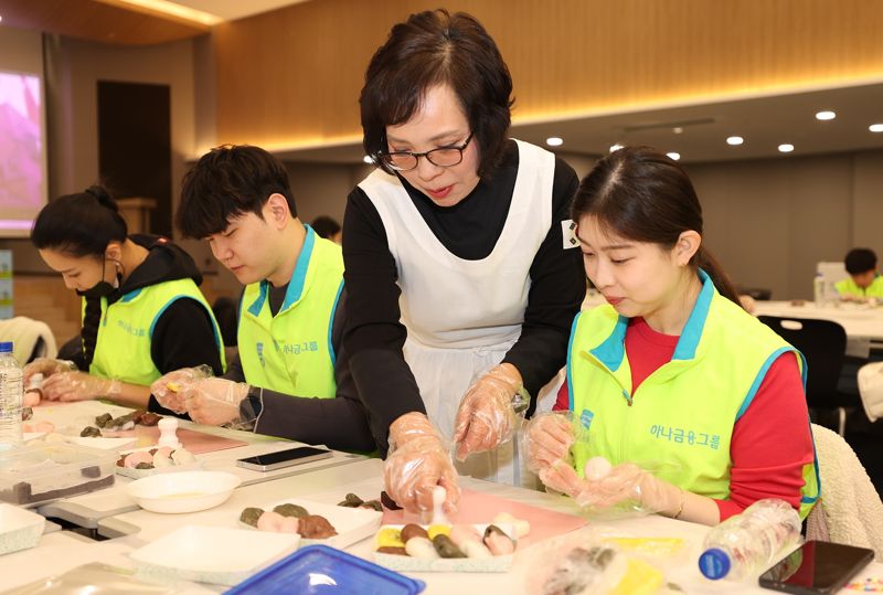 지난 3일 하나금융그룹 서울 명동사옥에서 열린 '설날맞이 사랑의 떡 나눔 봉사활동'에 참여한 하나금융그룹 임직원 및 가족들이 우리나라 전통 떡인 '바람떡'과 '꽃산병'으로 구성된 떡 세트를 만들고 있다. 사진=하나금융그룹 제공.