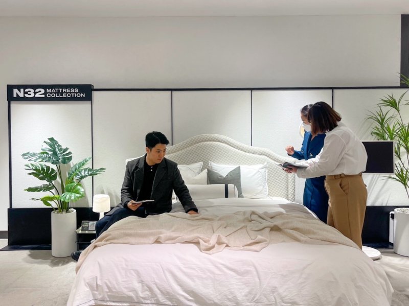 신세계백화점 센텀시티점에 문을 연 N32 매장을 찾은 소비자가 매트리스에 앉아보고 있다. (시몬스 제공)