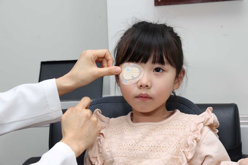 의료진이 환자에게 약시 치료를 위해 가림 패치를 붙이고 있다. 김안과병원 제공