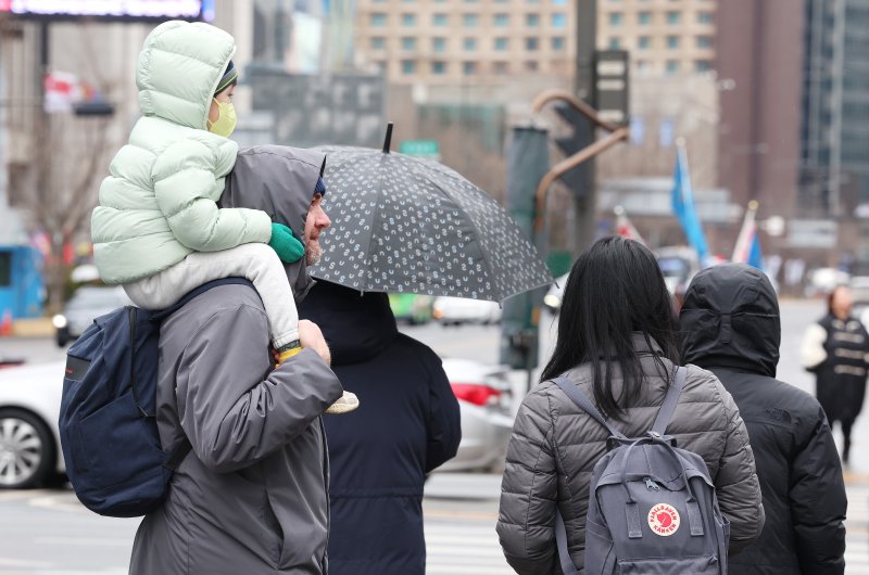 서울에 강한 바람과 눈비가 오락가락하며 변덕스러운 날씨를 보이는 5일 시민들이 횡단보도를 건너고 있다. 연합뉴스