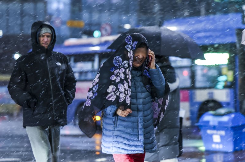 눈이 내린 5일 서울 마포구 공덕오거리에서 우산을 쓴 시민들이 이동하고 있다. 뉴시스