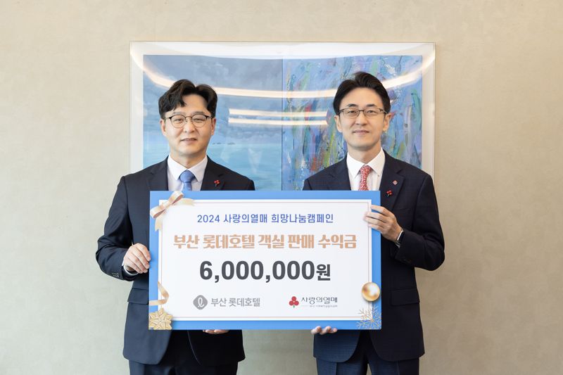 이동주 부산롯데호텔 총지배인(오른쪽)이 고객과 함께 모은 기부금 600만원을 박선욱 부산사랑의열매 사무처장에게 전달하면서 포즈를 취하고 있다. (주)부산롯데호텔 제공