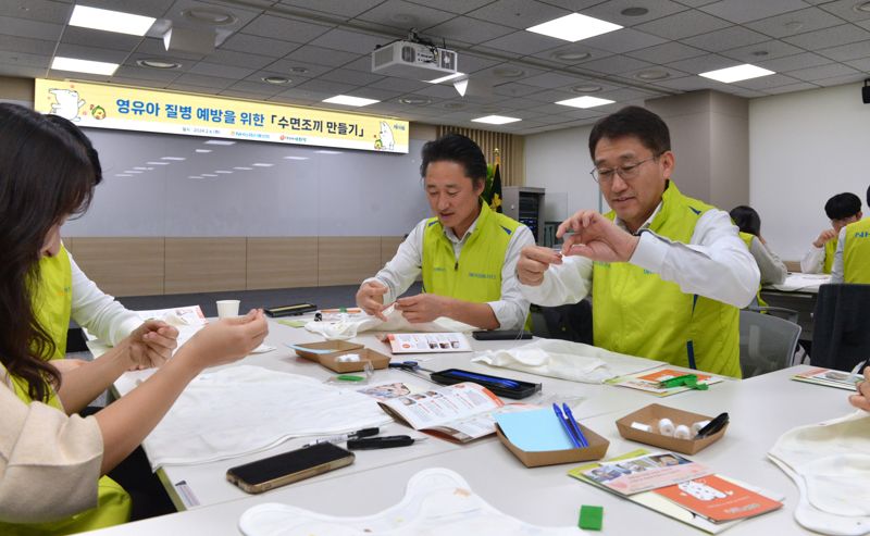 NH농협손해보험이 지난 6일, 서울 서대문구에 위치한 ‘구세군두리홈’을 찾아 미혼모자를 위한 수면조끼 및 아기용품을 전달하였다고 7일 밝혔다. 이에 앞서 서국동 대표이사(사진 오른쪽)와 직원 30여명이 수면조끼를 제작하고 있다. NH농협손해보험 제공