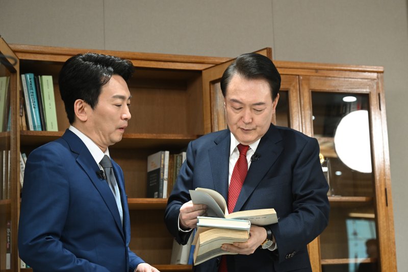 윤석열 대통령이 지난 4일 용산 대통령실 청사 집무실에서 진행된 KBS 신년 대담을 마친 후 박장범 KBS 앵커에게 집무실 책장을 소개하고 있다. (대통령실 제공) 2024.2.7/뉴스1 ⓒ News1 오대일 기자