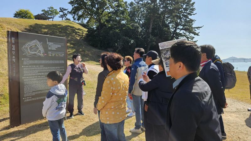 전남 완도군이 관광객을 대상으로 완도의 역사, 문화, 예술, 자연 등 관광자원에 대한 전문적인 해설 서비스를 제공하는 '문화관광 해설' 온라인 사전 예약 시스템을 본격 운영한다. 사진은 문화관광 해설가가 청해진 유적지에 대해 관광객들에게 설명해 주는 모습. 완도군 제공