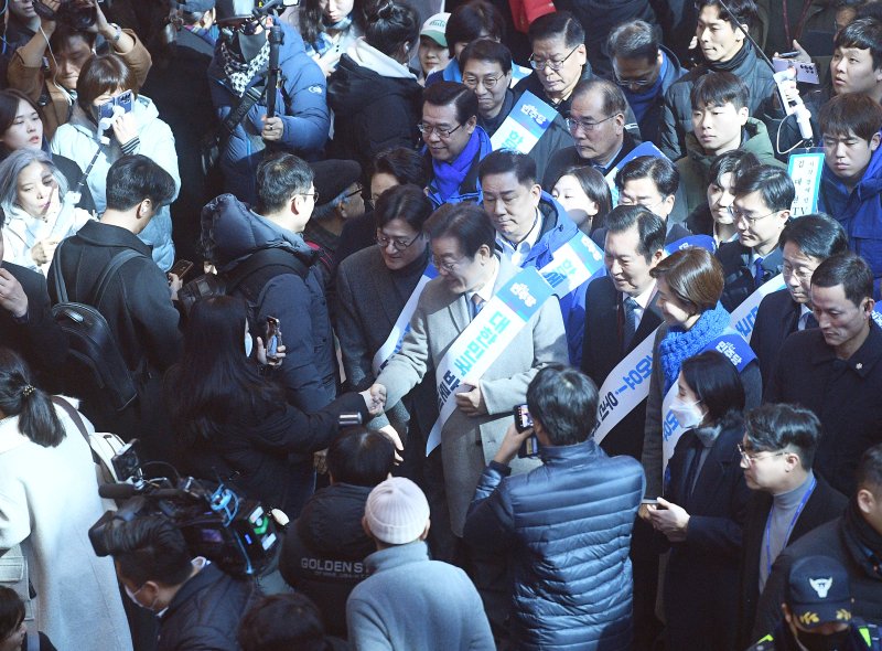 이재명 더불어민주당 대표가 서울 용산역에서 귀성길에 나선 시민들과 악수를 하고 있는 모습. 연합뉴스·뉴시스