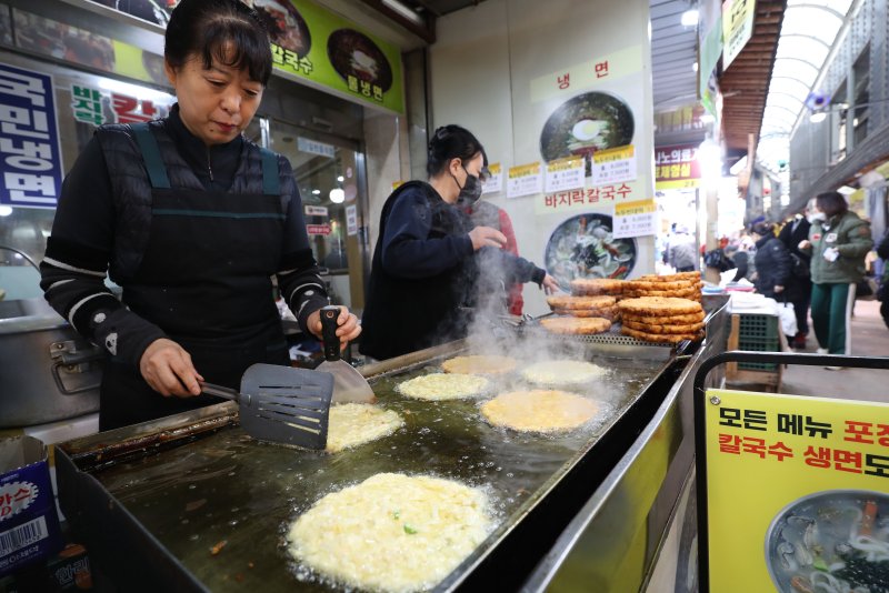 설 연휴를 하루 앞둔 8일 경기 수원시 팔달구 못골시장에서 상인들이 전을 부치고 있다. 2024.2.8/뉴스1 ⓒ News1 김영운 기자