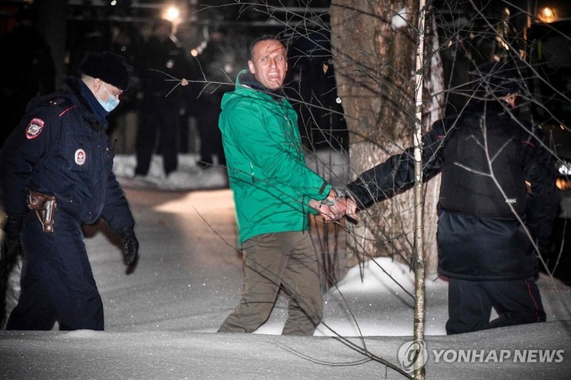 알렉세이 나발니 (FILES) Opposition leader Alexei Navalny is escorted out of a police station on January 18, 2021, in Khimki, outside Moscow, following the court ruling that ordered him jailed for 30 days. Russian opposition leader Alexei Navalny died on February 16, 2024 at the Arctic prison colony where h
