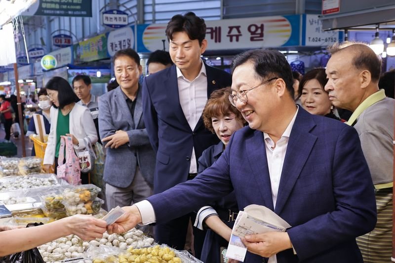 이장우 대전시장(오른쪽)이 지난해 9월 추석 명절을 앞두고 대전 대덕구 중리시장을 찾아 온누리상품권으로 성수품을 구입하며 상인들을 격려하고 있다. 대전시 제공