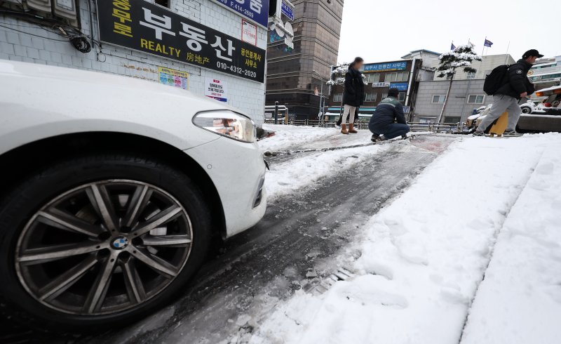 밤 사이 많은 눈이 내린 22일 오전 서울 중구 퇴계로 골목 오르막길에서 한 차량이 눈길을 오르지 못하고 견인되고 있다. 뉴시스