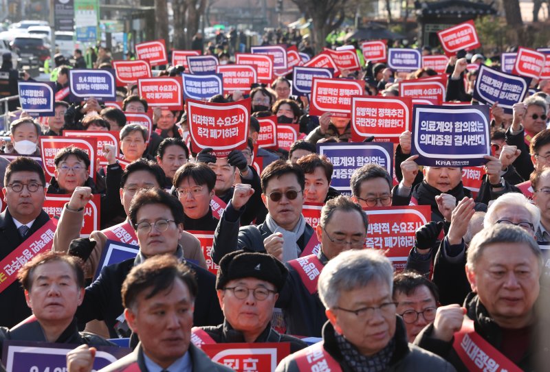 지난 25일 서울 대한의사협회에서 '의대 정원 증원 저지를 위한 전국 의사 대표자 확대회의'를 마치고 대통령실 앞으로 행진해 온 대한의사협회 비상대책위원회와 전국 의사 대표들이 구호를 외치고 있다. 뉴시스 제공