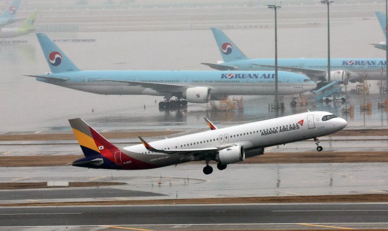 지난 1월 인천국제공항 계류장에 세워진 대한항공 항공기 앞으로 아시아나항공 항공기가 이륙하고 있다. 사진=뉴스1