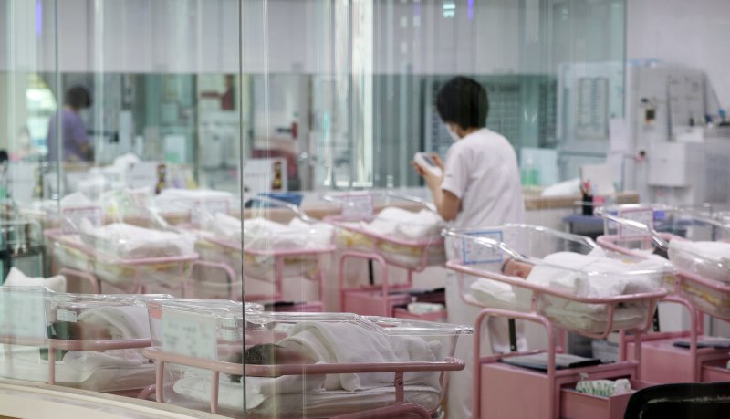 분기 출산율이 처음으로 0.6명대로 떨어지며 저출산 현상이 이어지고 있는 가운데 28일 오후 서울 시내 한 산후조리원 신생아실에서 한 관계자가 신생아를 돌보고 있다. 연합뉴스