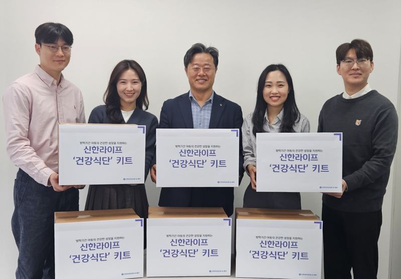 신한라이프빛나는재단 김순기 사무국장(왼쪽 세번째)과 신한라이프 임직원들이 결식 우려 아동에게 전달할 건강식단 키트와 함께 서 있다.신한라이프제공