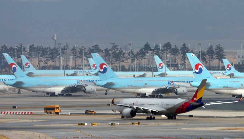 지난달 13일 인천국제공항 활주로에서 아시아나항공 항공기가 대한항공 항공기 앞을 지나고 있다. 뉴스 1