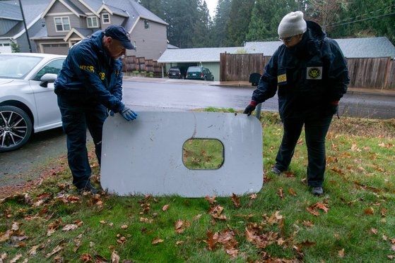 미국 국가교통안전위원회(NTSB) 조사관들이 지난 1월 8일(현지시각) 오리건주 포틀랜드 주택가에서 발견된 알래스카 항공 1282편 보잉 737 맥스 9의 도어 플러그를 살펴보고 있다. 연합뉴스