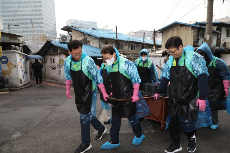 NH투자증권 임직원들이 지난해 12월 7일 영등포 쪽방촌을 찾아 연탄나눔 봉사를 하고 있다.