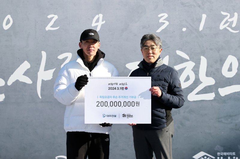 지난 1일 서울 마포구 월드컵경기장에서 열린 '3·1런' 행사에서 서희종 대우건설 상무(오른쪽)가 기부금 2억원을 전달하고 있다. 대우건설 제공