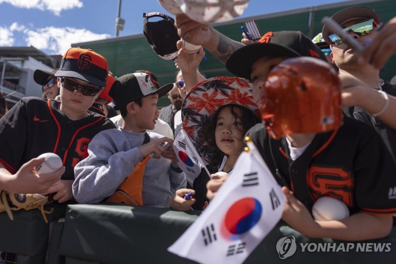 태극기 흔들며 이정후 사인 기다리는 어린 팬들 Young fans, some with South Korean flags, hope for an autograph from San Francisco Giants' Jung Hoo Lee during a spring training baseball game against the Cleveland Guardians, Sunday, March 3, 2024, in Goodyear, Ariz. (AP Photo/Carolyn Kaster)