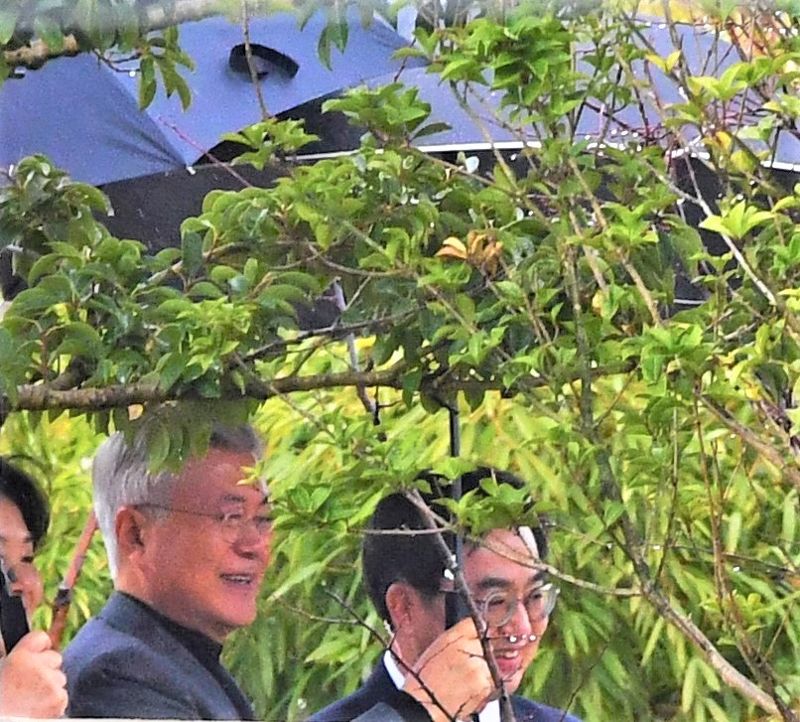 문재인 전 대통령이 5일 경남 양산시 하북면 평산마을 사저를 찾은 김동연 경기도지사에게 우산을 직접 씌워주고 있다. 뉴시스