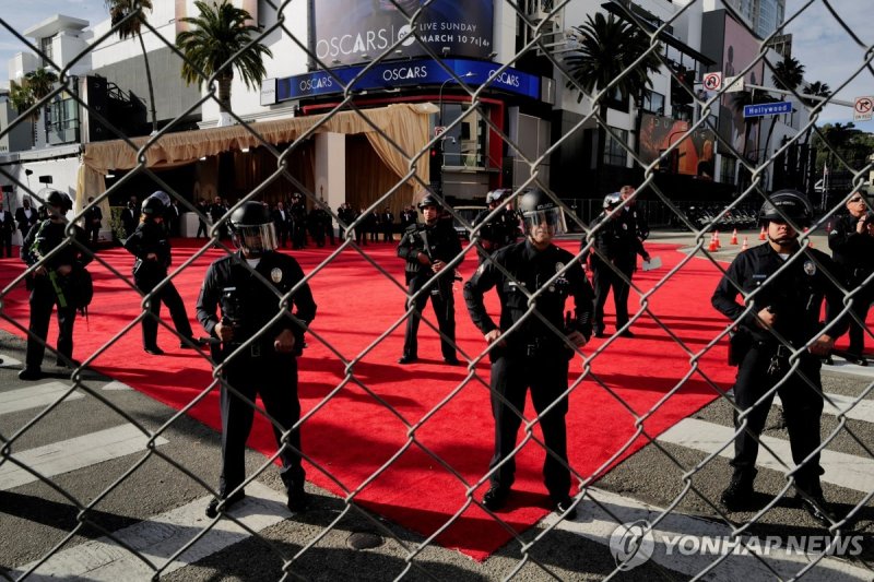 Members of security stand guard as pro-Palestinian demonstrators take part in a protest near the perimeter of the 96th Academy Awards, amid the ongoing conflict between Israel and the Palestinian Islamist group Hamas, in Los Angeles, California, U.S., March 10, 2024. REUTERS/Carlin Stiehl TPX IMAGES