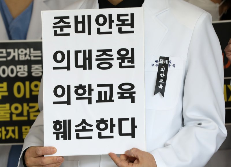 부산대병원·부산대 교수진과 의대생들이 지난 11일 경남 양산시 물금읍 부산대 양산캠퍼스 의과대학에서 의과대학 정원 확대 정책과 관련해 정부에 조건 없는 대화를 촉구하는 기자회견을 하고 있다. 뉴스1