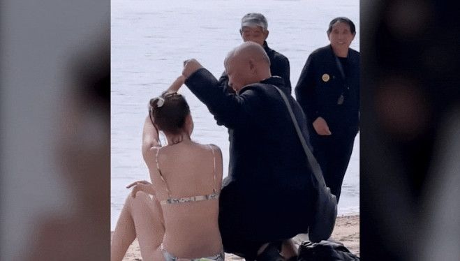지난 5일 홍콩의 한 해변에서 중국 중년 남성들이 비키니 차림으로 일광욕을 즐기던 백인 여성에게 접근에 강제로 사진찍기를 시도하고 있다.<div id='ad_body3' class='mbad_bottom' ></div> 사진=틱톡 캡처