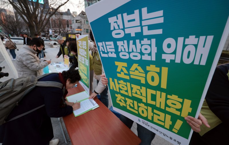 13일 오후 서울 종로구에서 보건의료노조가 의사들의 진료거부 중단을 촉구하는 범국민 서명운동을 하고 있다. 연합뉴스