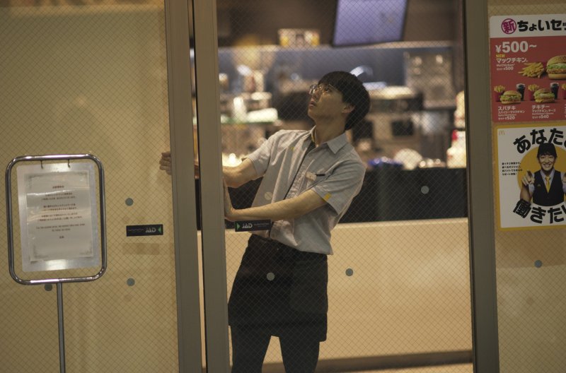 일본 도쿄의 한 맥도날드 매장 직원이 15일 시스템 결함에 따른 영업차질로 평소보다 일찍 매장 문을 닫고 있다. 맥도날드는 이날 호주, 일본, 영국, 미국 등 전세계 곳곳 매장에서 온라인 주문, 카드결제 등이 먹통이 되면서 혼란을 겪었다. AP뉴시스